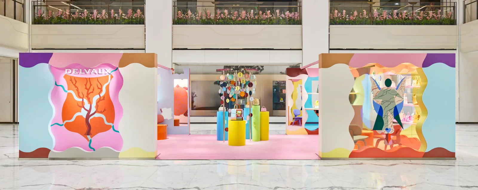 Symmetrical front elevation of a colourful Delvaux pop-up with a central product display in Beijing.
